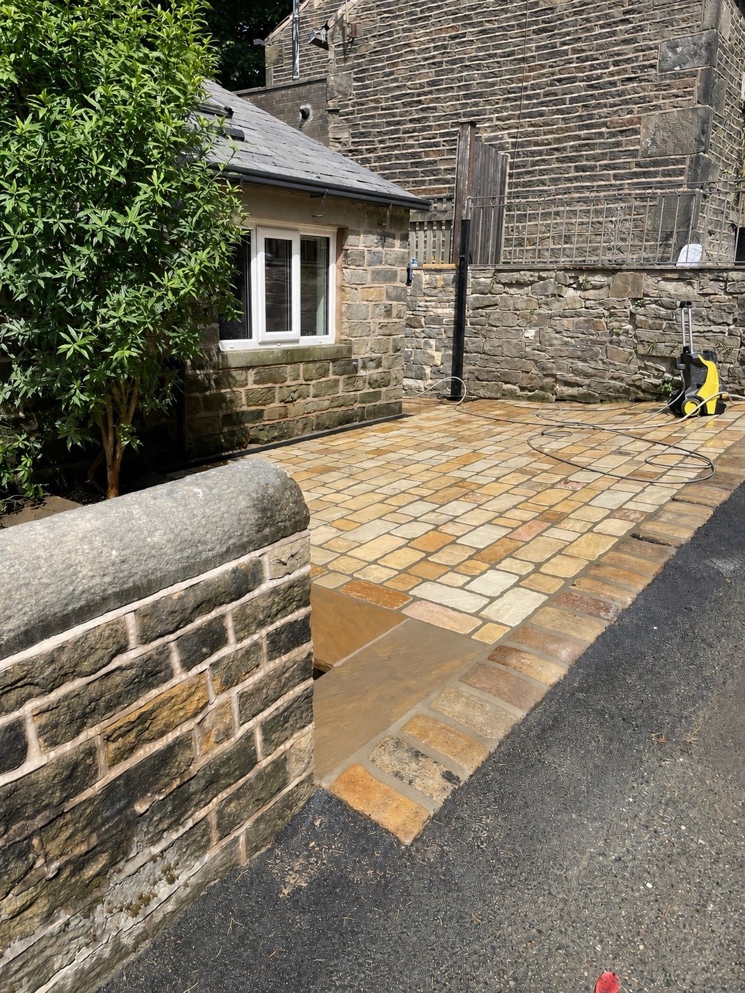 Sett paving leading to a stone outbuilding
