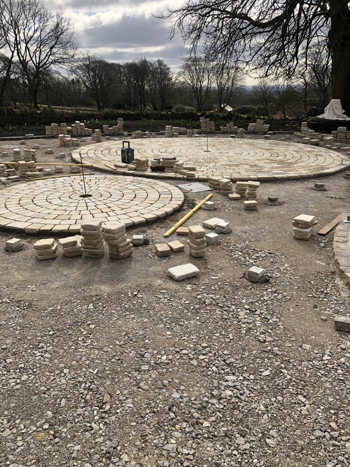 Circular sett paving being laid in a rural courtyard