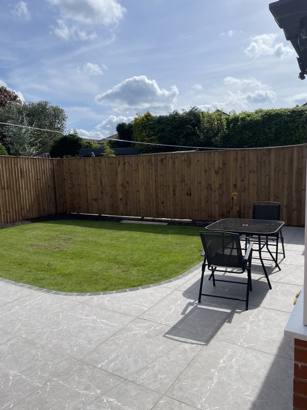 New patio with lawn edge and garden furniture