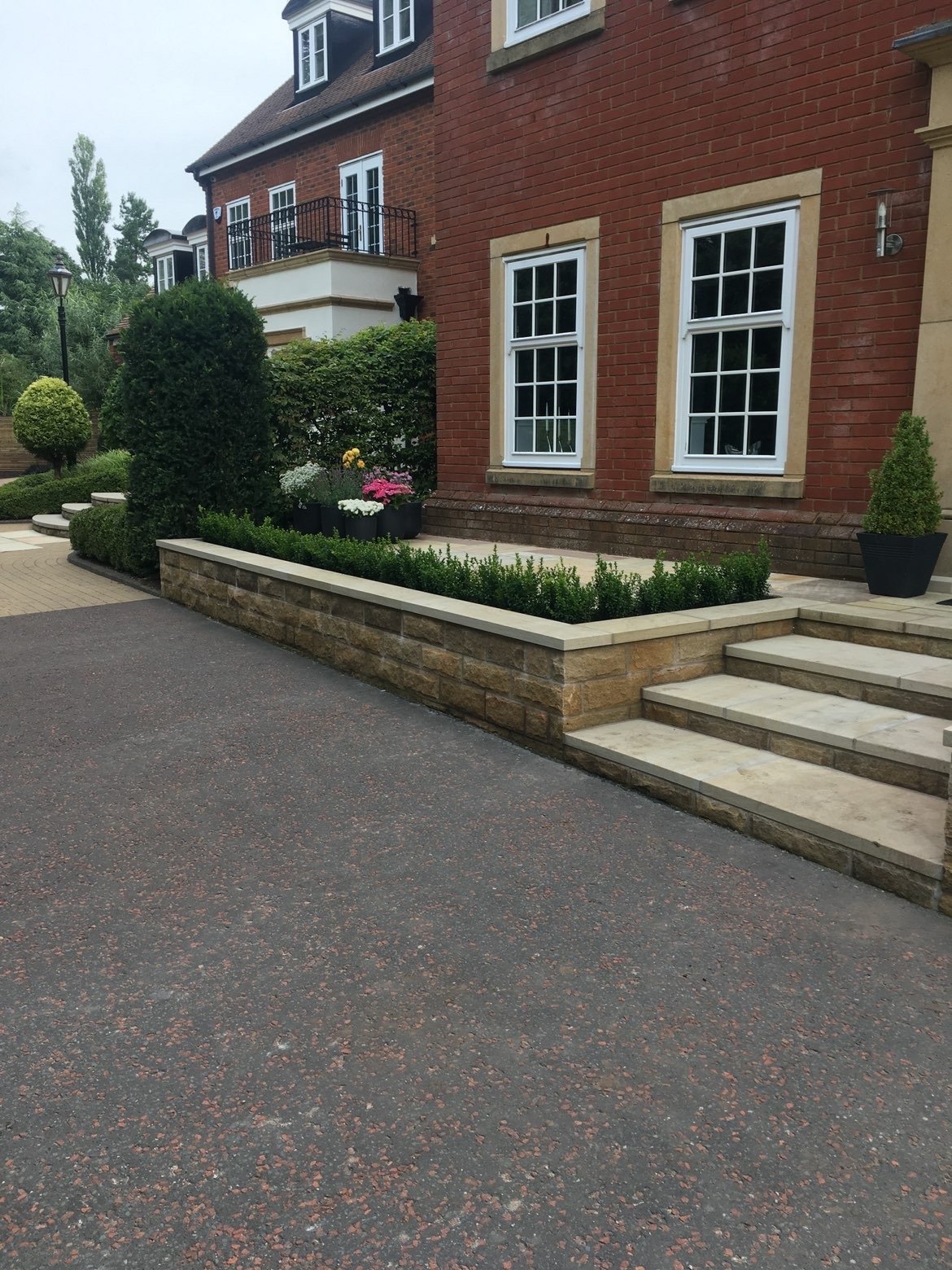 Stone retaining wall and steps with box hedging